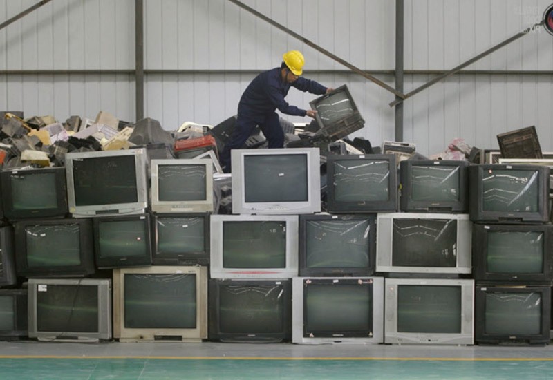 Сотрудники перерабатывающего завода сортируют телевизоры